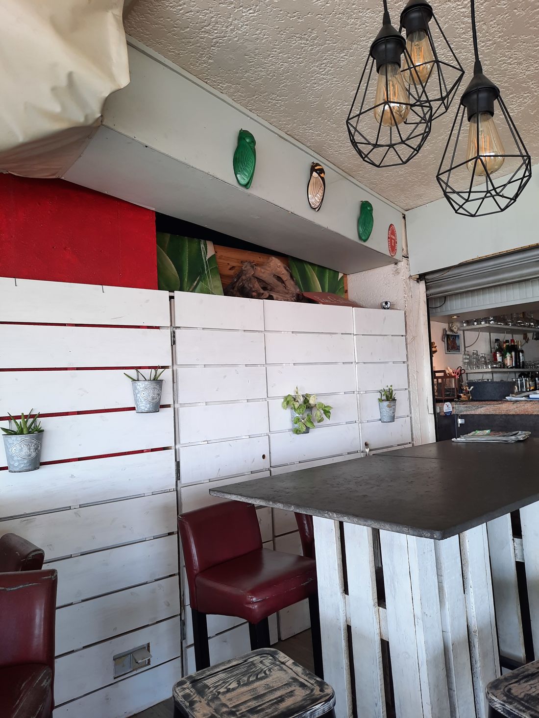 Le coin bar : palettes blanchies, tabourets, suspensions à filaments